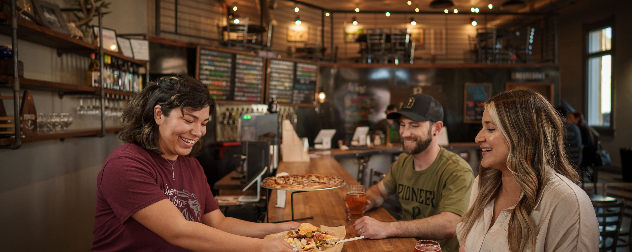 a couple being served nachos at a brewery