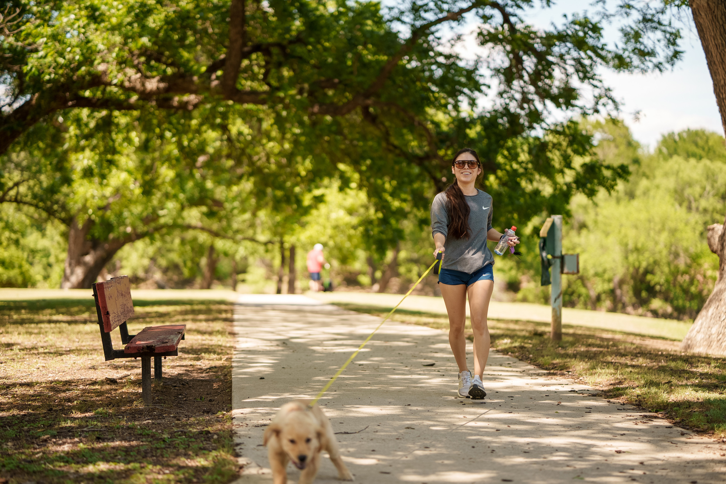 woman running with her puppy in a park